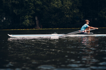 Sportsman single scull man rower rowing on boat. © primipil