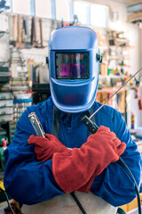 A man welder with safety helmet working with arc welding machine in the workshop