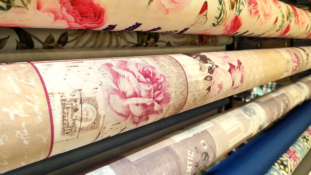 rolls of wrapping paper and oilcloths with ornaments to decorate on a store display - closeup view