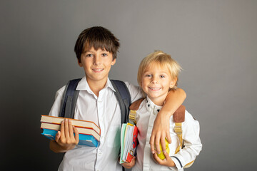 Cute preschool blond child, boy, holding books and notebook, apple, wearing glasses, ready for school