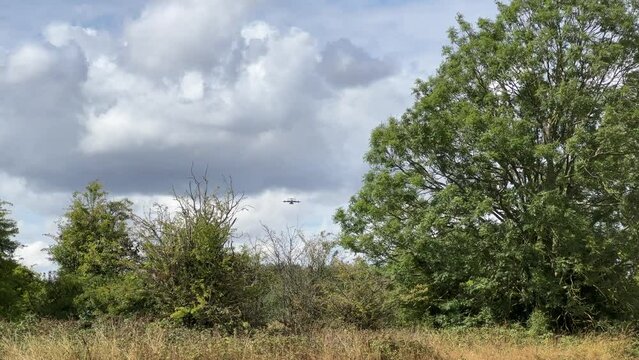 Royal Air Force Airbus A400M Atlas military plane (RAF ZM414) flying low level dropping 3 PARA parachute regiment soldiers on an airborne assault military exercise, summer bright cloud sky
