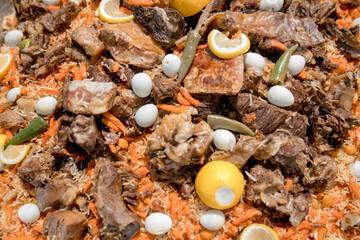 Traditional oriental pilaf in a cauldron on a wooden table on a sunny day.