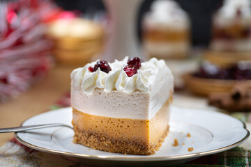 Christmas pumpkin and cranberry mousse on cake stand, on a festive table