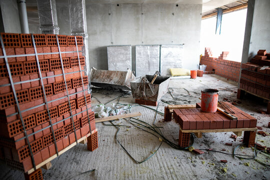 Red clay bricks are stacked on wooden pallets. Production of bricks from clay.