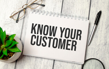 Know Your Customer words and calculator, pen and glasses on wooden background