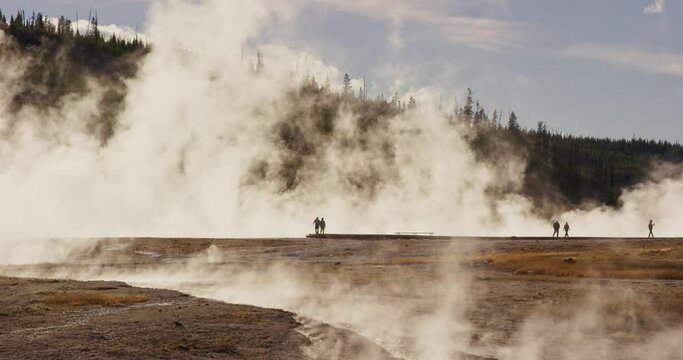 Steam rising from Grand Prismatic with the silhouettes of people in Yellowstone National Park