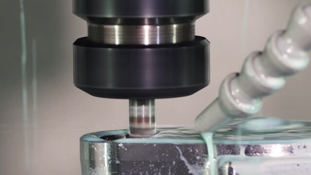 Close Up of Milling machine cutting the work piece and fluid cools machined part. High pressure coolant a great option for chip removal and evacuation as it blasts the chips away from the part

