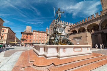 Bologna, Italy - August 21, 2022: street view of the Fondana di Nettuno in Bologna, people are visible in the far distance under a blue sky of summer. © CesareFerrari