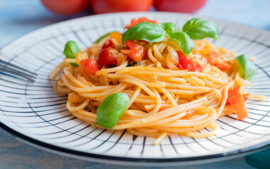 Italian pasta in a restaurant with tomato sauce and basil