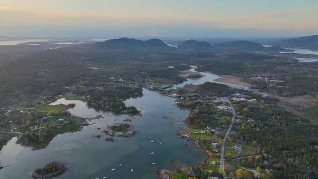 Bass Harbor and village aerial view at sunset with Mountains in Acadia National Park at the background in town of Tremont on Mt Desert Island, Maine ME, USA. 