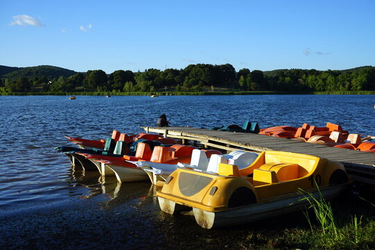 Bunte Tretboote aus Kunststoff im Licht der Abendsonne an einem Bootssteg im Sommer am Poyrazlar See im Tabiat Park bei Adapazari in der Provinz Sakarya in der T&uuml;rkei