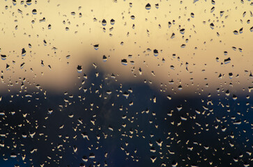 water drops on the window on sunset orange and black background