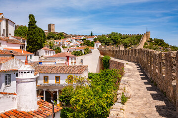 The castle and towers of the historic old town of Obidos with the city walls you can walk through,...