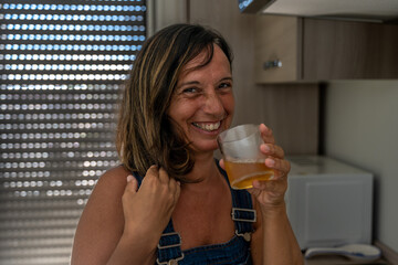 image of a beautiful middle aged woman drinking a cocktail in her apartment