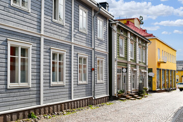 Colorful and picturesque shops and wooden buildings line the main cobblestone road through the medieval Old Town of Porvoo, Finland