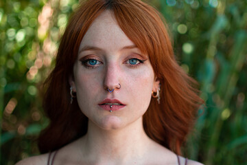 Young redhead caucasian woman serious face outdoor portrait
