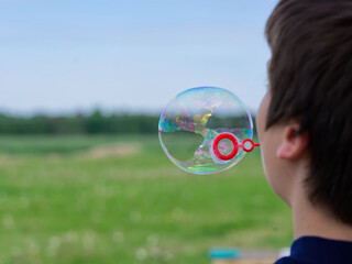 The child blows soap bubbles in nature. close up