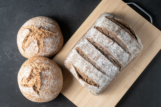 Vision cenital de pan artesanal sobre fondo negro y madera