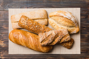 Assortment of freshly baked bread with napkin on rustic table top view. Healthy unleavened bread. French bread