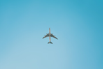 The plane flies against the blue sky. Travels.