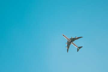 The plane flies against the blue sky. Travels.