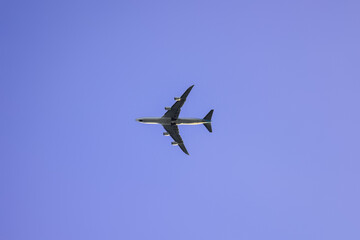 The plane flies against the blue sky. Travels.