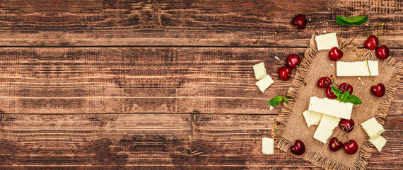 Ripe sweet cherries with fresh mint leaves and white chocolate, traditional summer fruits