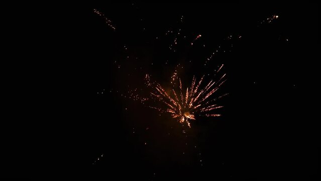 Small new year eve fireworks - bright glowing explosions on dark sky