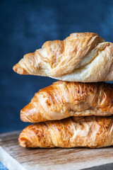 Fresh fragrant croissants lie on a cutting board. Close-up. Home baking, bakery.