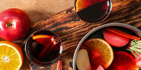 Glasses and pot of delicious mulled wine on table, top view
