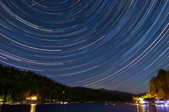 Star trails and Northern Lights at Deer Lake with blue sky and colorful stars and lake reflections