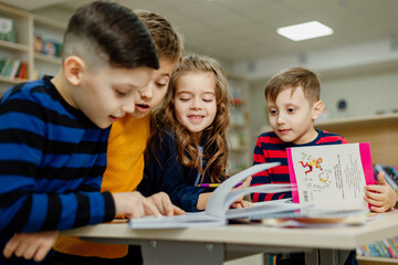 school children in the library reading books, doing homework, prepare a school project for lessons