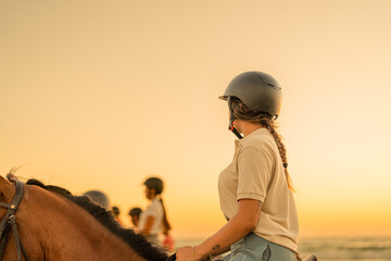 young woman with braid riding on horseback observing her companions