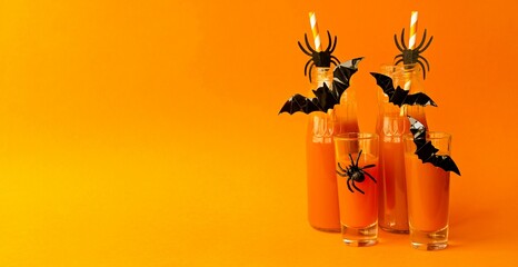 Banner, on an orange background, festive pumpkin cocktails, drinks for the Halloween holiday in...