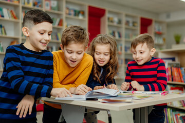 school children in the library reading books, doing homework, prepare a school project for lessons © Tina kids photo