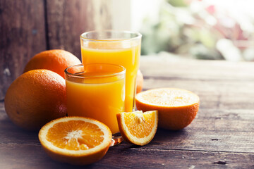 glasses of fresh Orange juice over rustic wooden background 