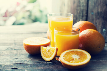 glasses of fresh Orange juice over rustic wooden background 