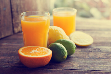 glasses of fresh Orange juice over rustic wooden background 
