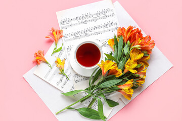 Composition with cup of tea, alstroemeria flowers and music notes on pink background