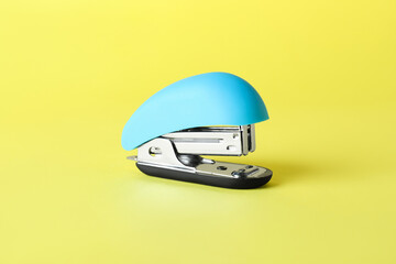 Blue stapler on yellow background