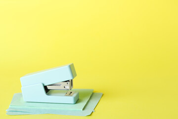 Stapler with sticky notes on yellow background