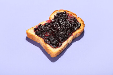 Toast with sweet jam on lilac background