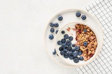 Bowl of homemade yogurt with granola and blueberries. Top view, copy space for text