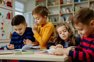 school children in the library reading books, doing homework, prepare a school project for lessons