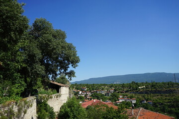 Schöne traditionelle alte Wohnhäuser vor blauem Himmel im Sonnenschein an einem Berghang im...