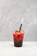 Watermelon bubble tea or fruit boba drink in disposable plastic take away cup. Delicious iced...