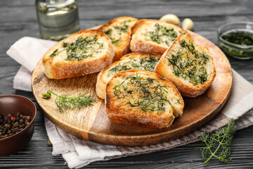 Plate of toasts with garlic and dill on dark wooden table, closeup