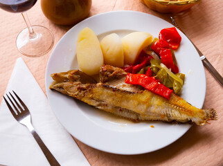 Dish of spanish cuisine - roasted maragota fish (ballan wrasse) with vegetables