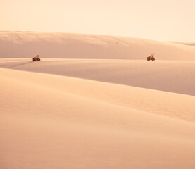 Fototapeta na wymiar quads driving through the sand dunes in the desert