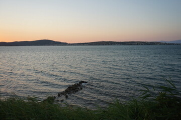 Romantische Abendstimmung mit dem Licht der Abendsonne am Strand in der Bucht von Ayvalik am...